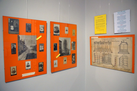 Fragment ekspozycji - na fotografii widoczne trzy antyramy ze zdjęciami ukazującymi dawnych mieszkańców Kluczborka, fragmenty miasta, oraz plany budynków.